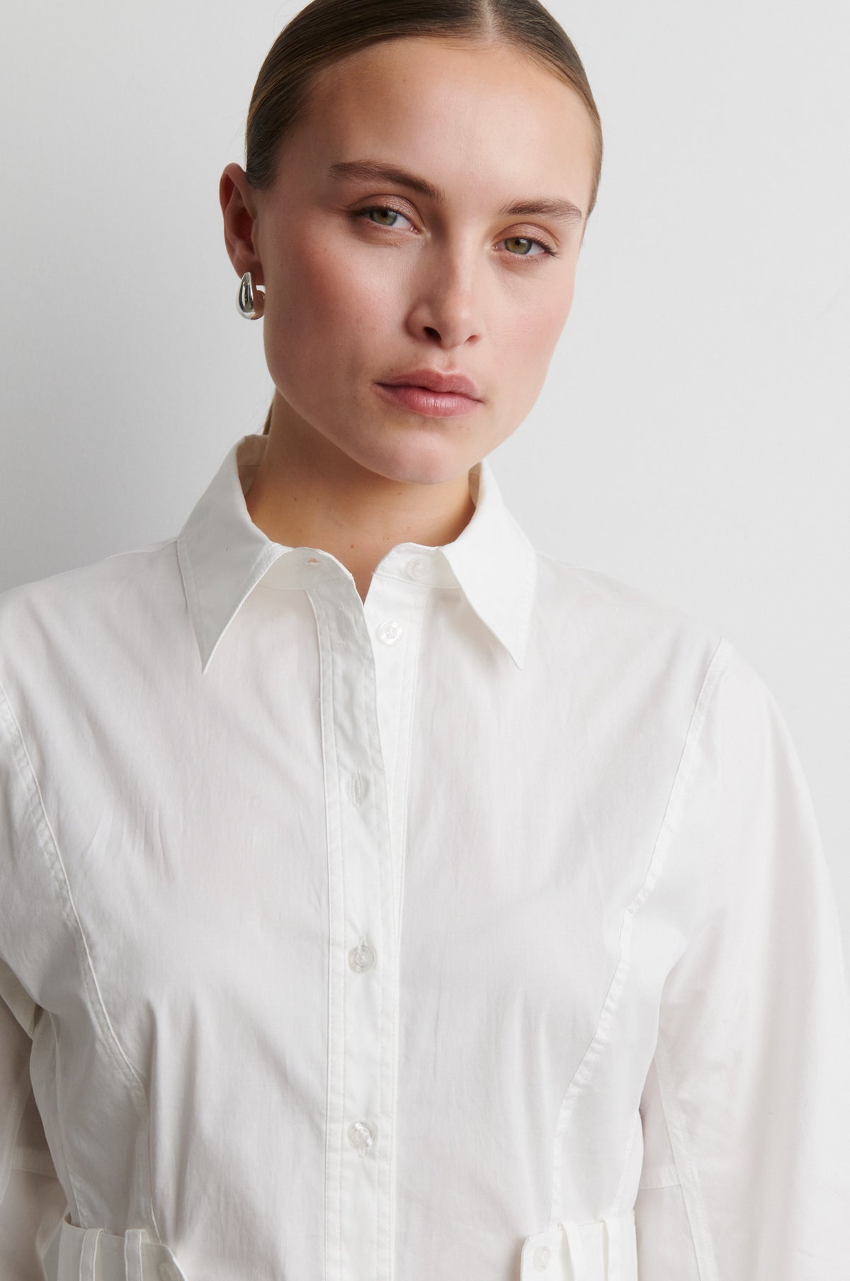 Woman wearing a white shirt against a plain background from Second Female