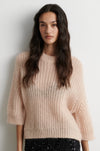 Open weave pale pink short sleeve jumper worn with sequin skirt