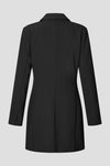 A black longline blazer dress shown from the back, featuring a structured collar and long sleeves, photographed against a solid light gray background.