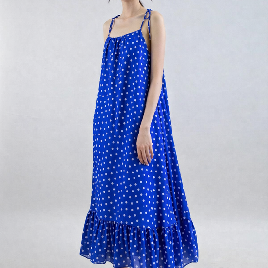 Woman wearing a blue polka dot dress on a white background