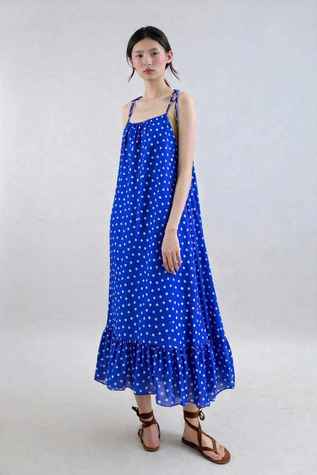 Woman wearing a blue polka dot dress on a white background