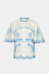 White blouse with blue embroidery on a white background