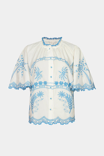 White blouse with blue embroidery on a white background