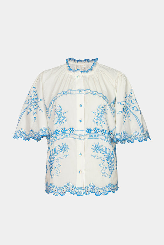 White blouse with blue embroidery on a white background