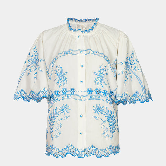 White blouse with blue embroidery on a white background