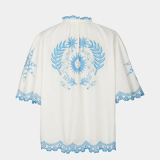 White garment with blue floral embroidery on a white background