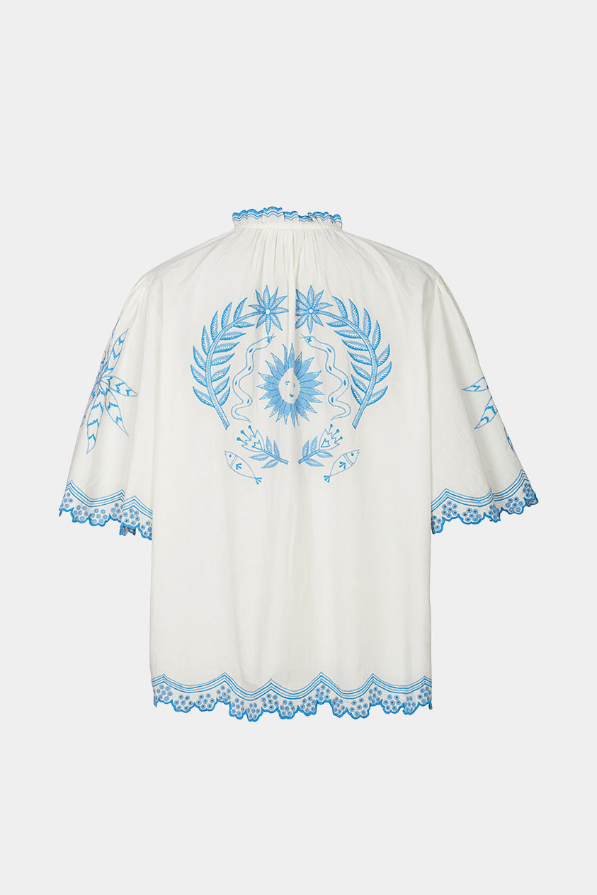 White garment with blue floral embroidery on a white background