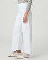 Person wearing white wide-leg paige jeans on a plain background side view