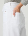 Person wearing white wide-leg paige jeans on a plain background close up