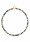 A beaded necklace made of small round natural stone beads in earthy green, brown, gray, and black tones, separated by small gold spacer beads and a gold clasp, shown on a plain white background.