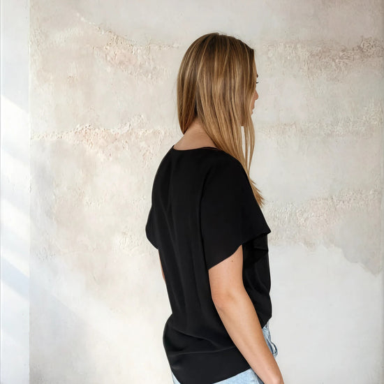Rear view of black flutter sleeve top from Sirens