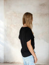 Rear view of black flutter sleeve top from Sirens