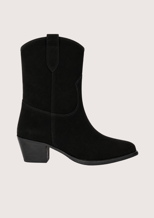 A black suede western-style ankle boot with a low block heel, shown from a side profile against a light beige background.