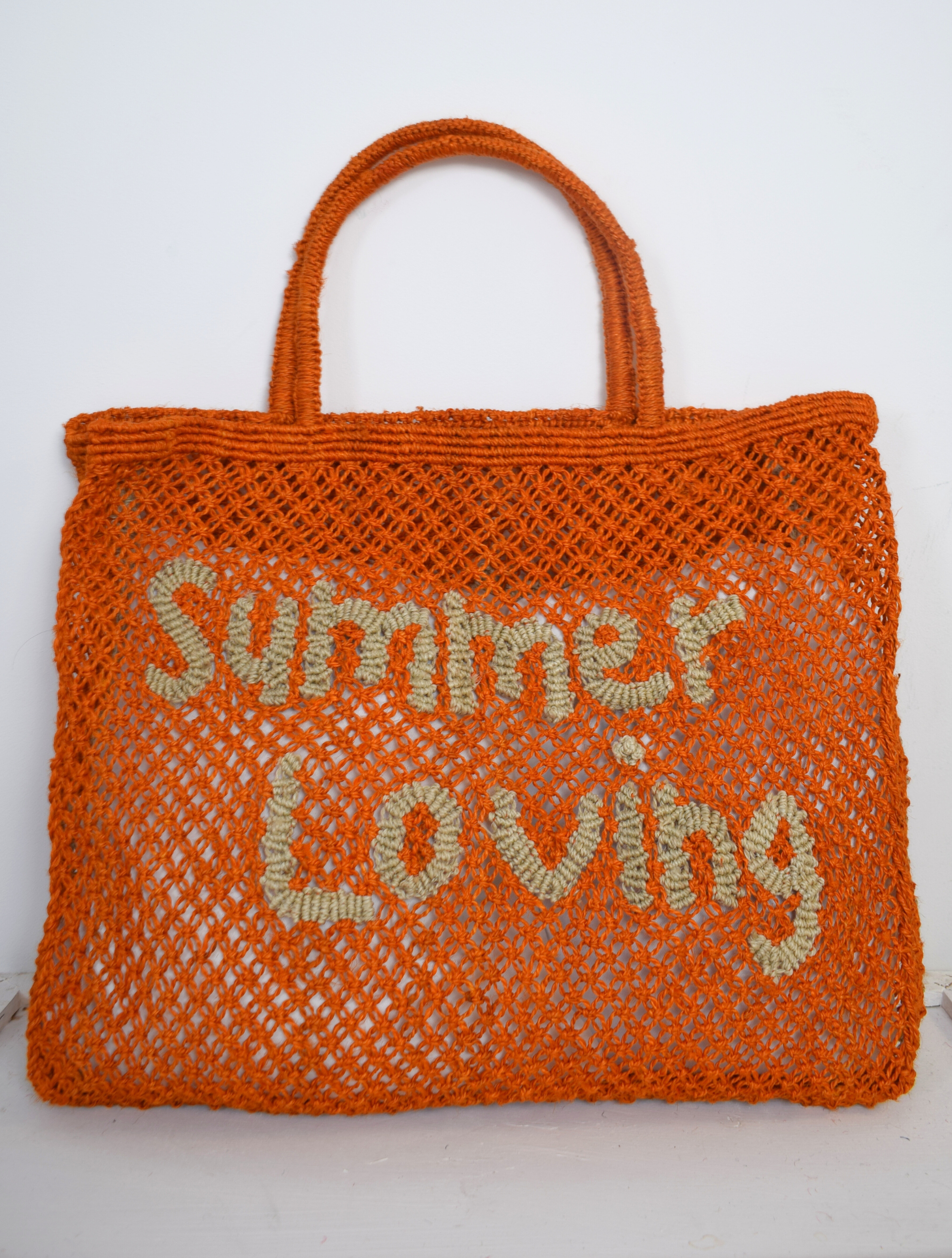 Orange woven bag with neutral writing