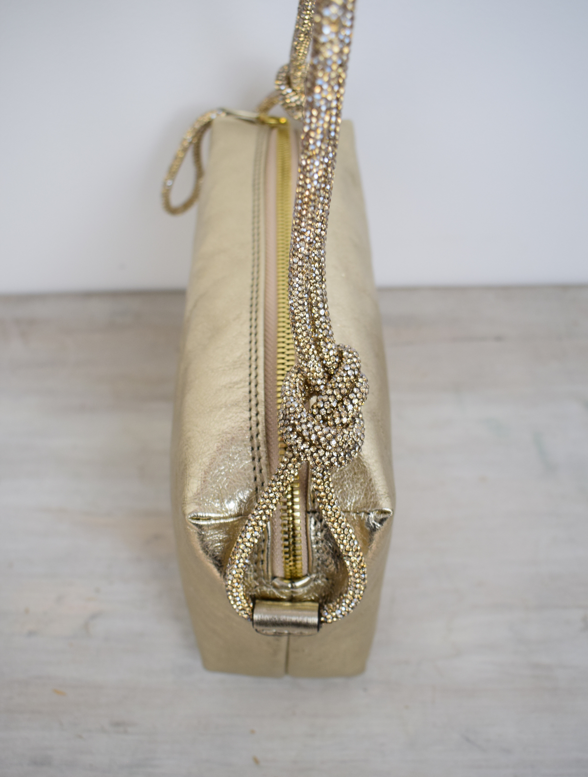 rectangular gold coloured leather bag with sparkly knotted shoulder strap