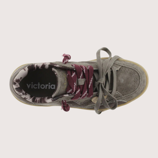 A low-top platform sneaker in dark gray suede and leather, featuring a thick beige gum sole, gray laces, and burgundy ribbon laces tied in a bow.