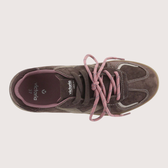 A low-top sneaker in dark brown suede and canvas with dusty pink laces and a tan gum sole, shown from a side profile on a light gray background.