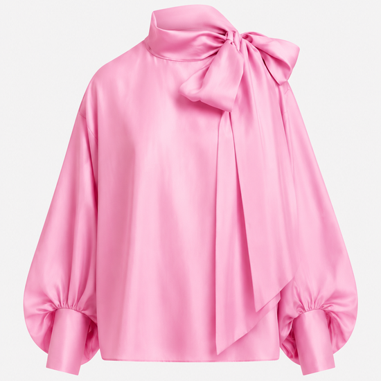 A pink satin blouse with a large bow at the high neck, balloon sleeves, and gathered cuffs, shown on a plain light gray background.