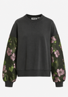 A dark charcoal gray crewneck sweatshirt with long sleeves featuring a green floral print with pink flowers, shown against a plain white background.