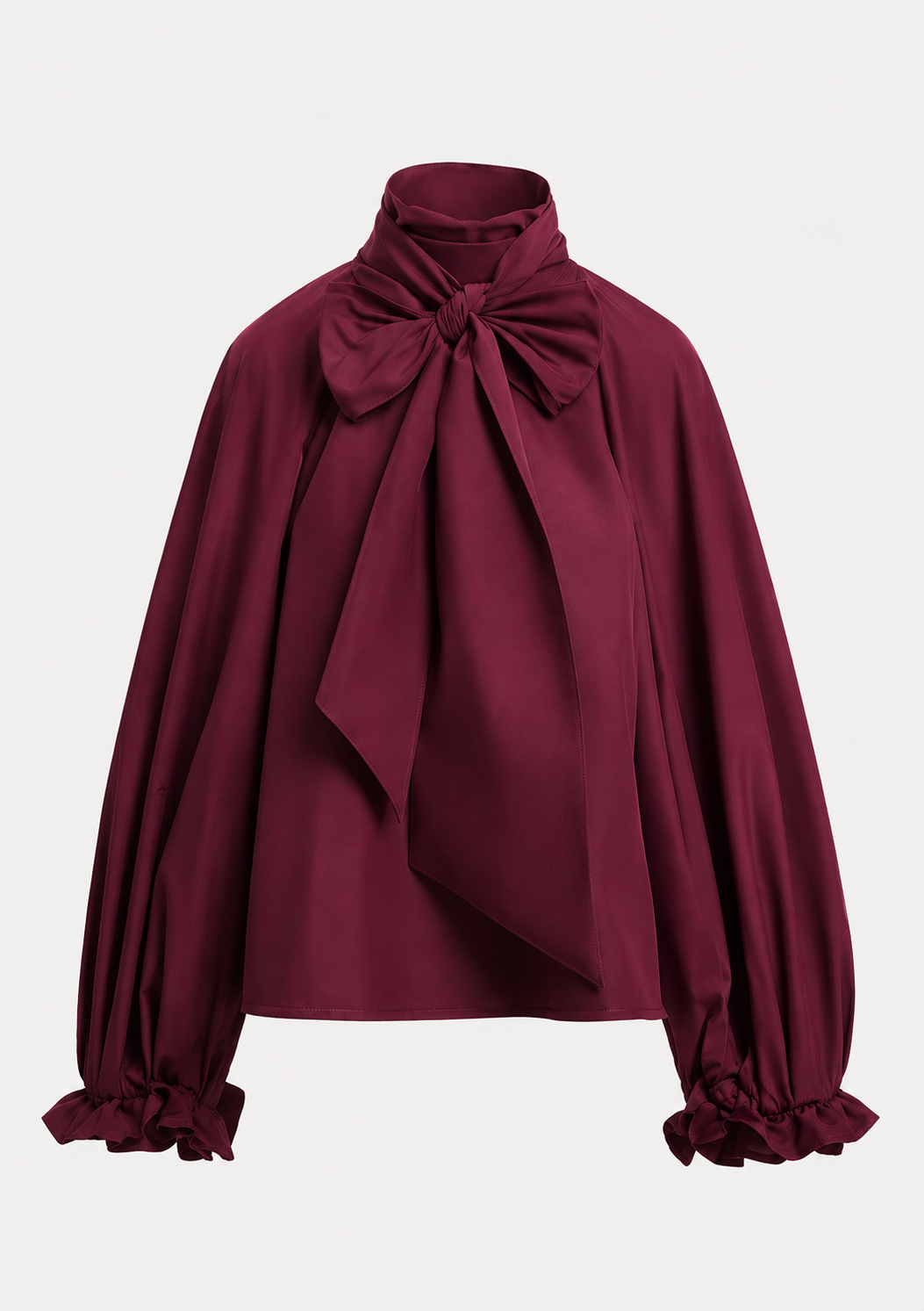 A deep burgundy long-sleeve blouse with a large bow at the high neck, draped front detail, and ruffled cuffs, shown on a light gray background.
