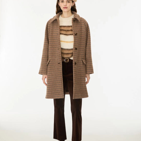 Woman wearing a brown check wool coat and a beret
