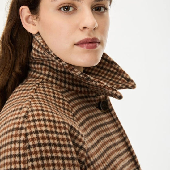 Woman wearing a brown check wool coat close up