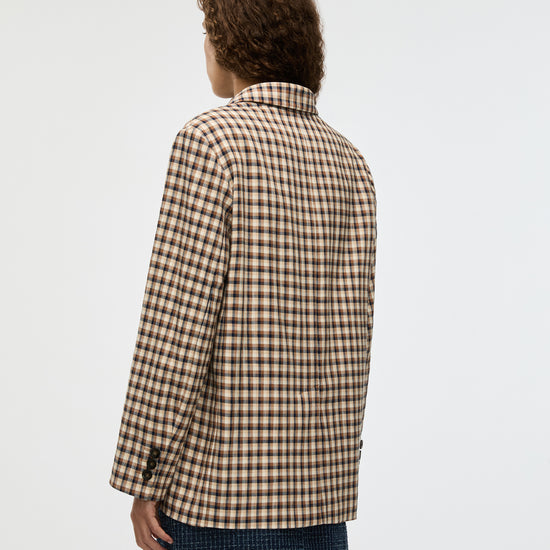 Person wearing a checkered jacket on a plain background