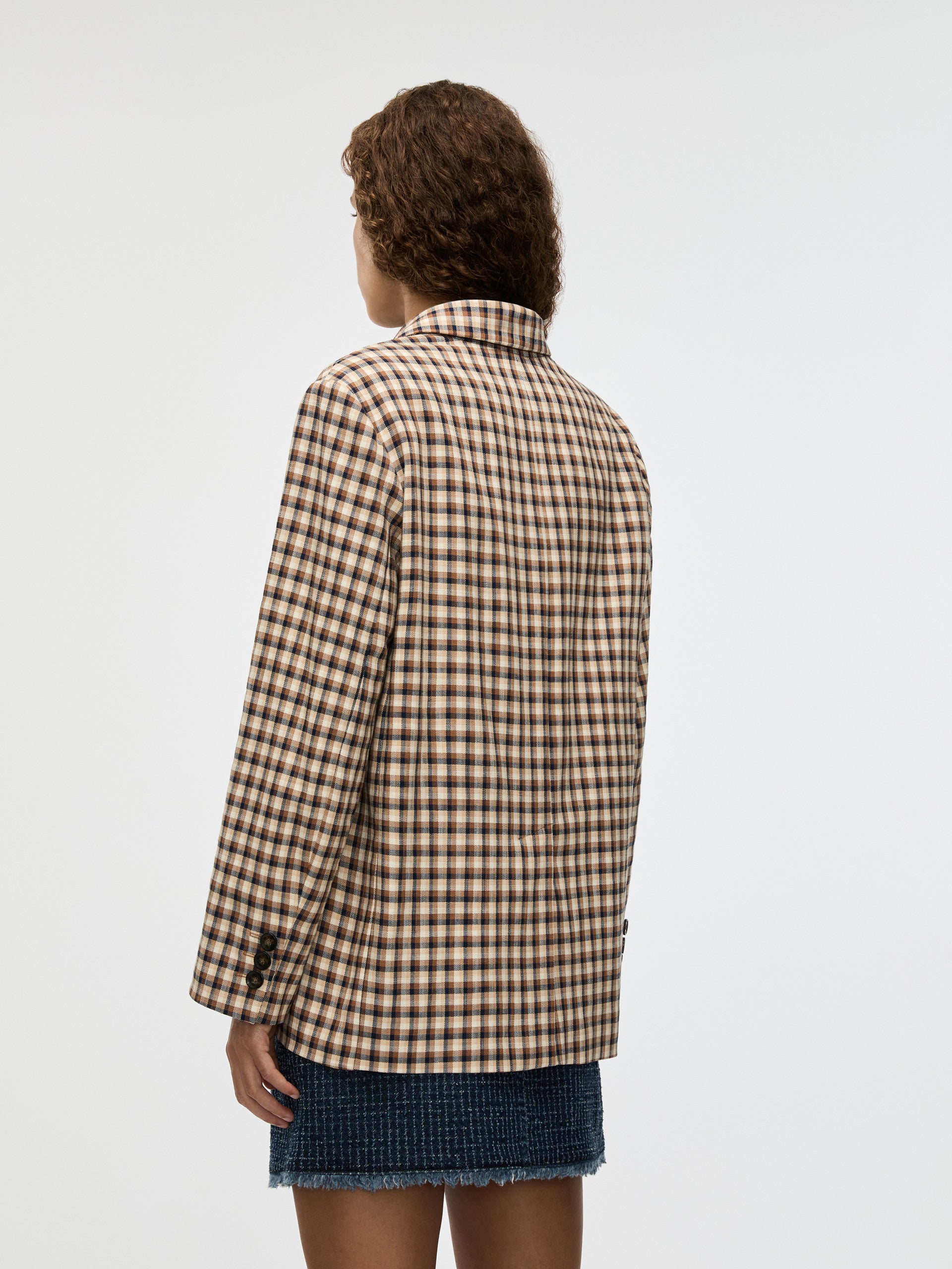 Person wearing a checkered jacket on a plain background