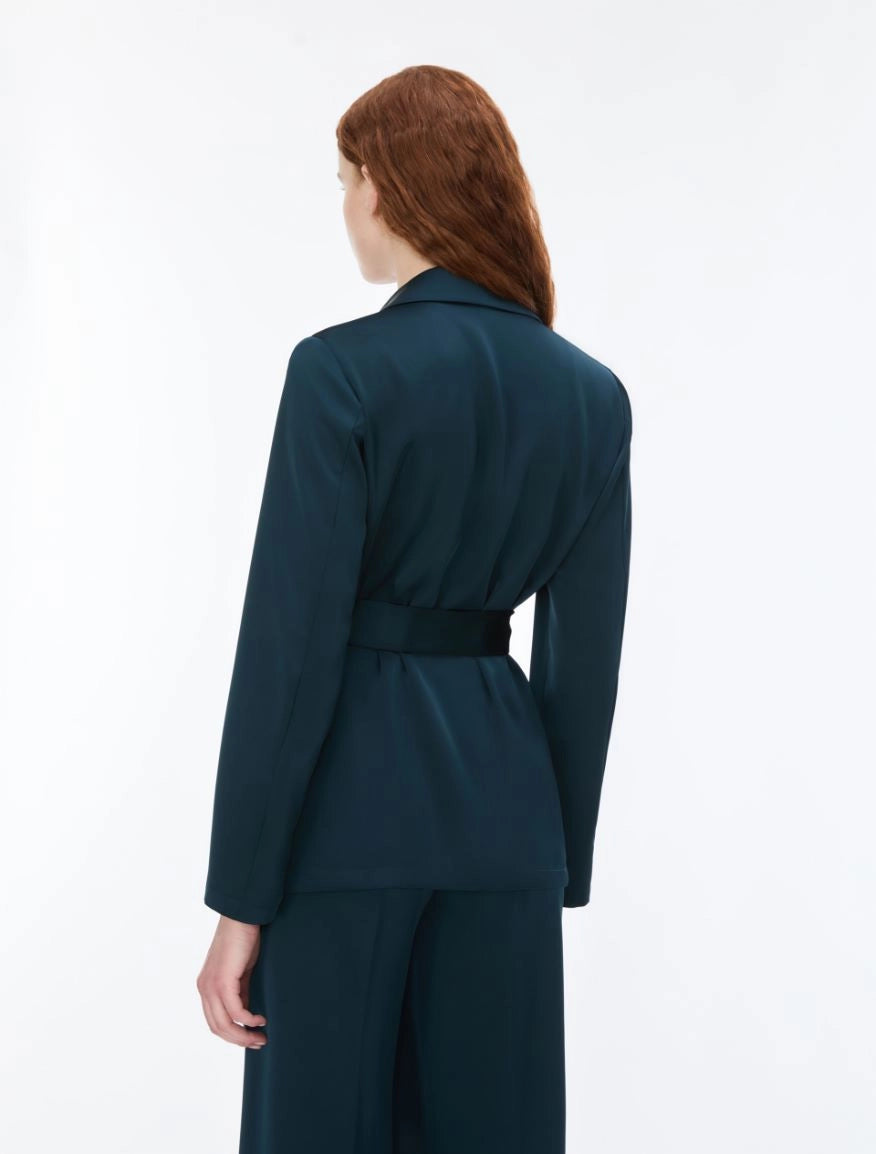 Woman wearing dark teal blazer and trousers rear view