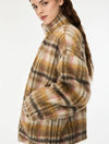 woman wearing khaki and pink check coat on a white background side view