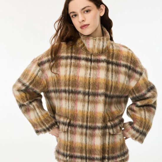 A woman modeling a fuzzy, long-sleeve plaid jacket with a mock neck and tie waist, in a beige, brown, and yellow plaid pattern, against a plain white background.