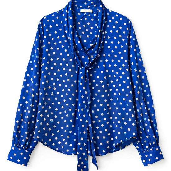 Blue polka dot blouse with a tie detail on a white background