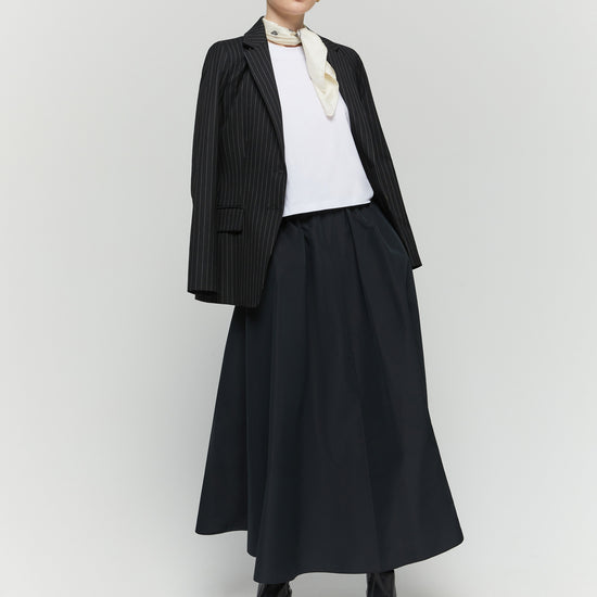 Model shot of black elasticated skirt worn with blazer