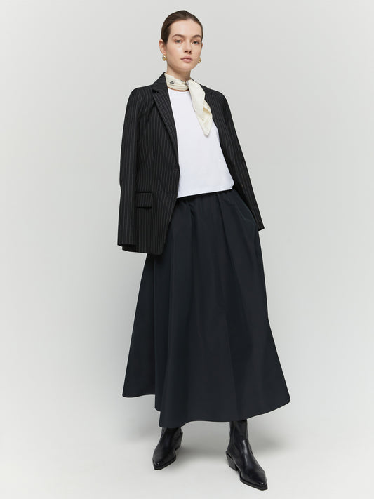 Model shot of black elasticated skirt worn with blazer