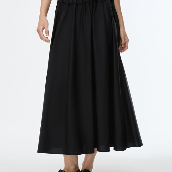 Person wearing a black skirt with a white background