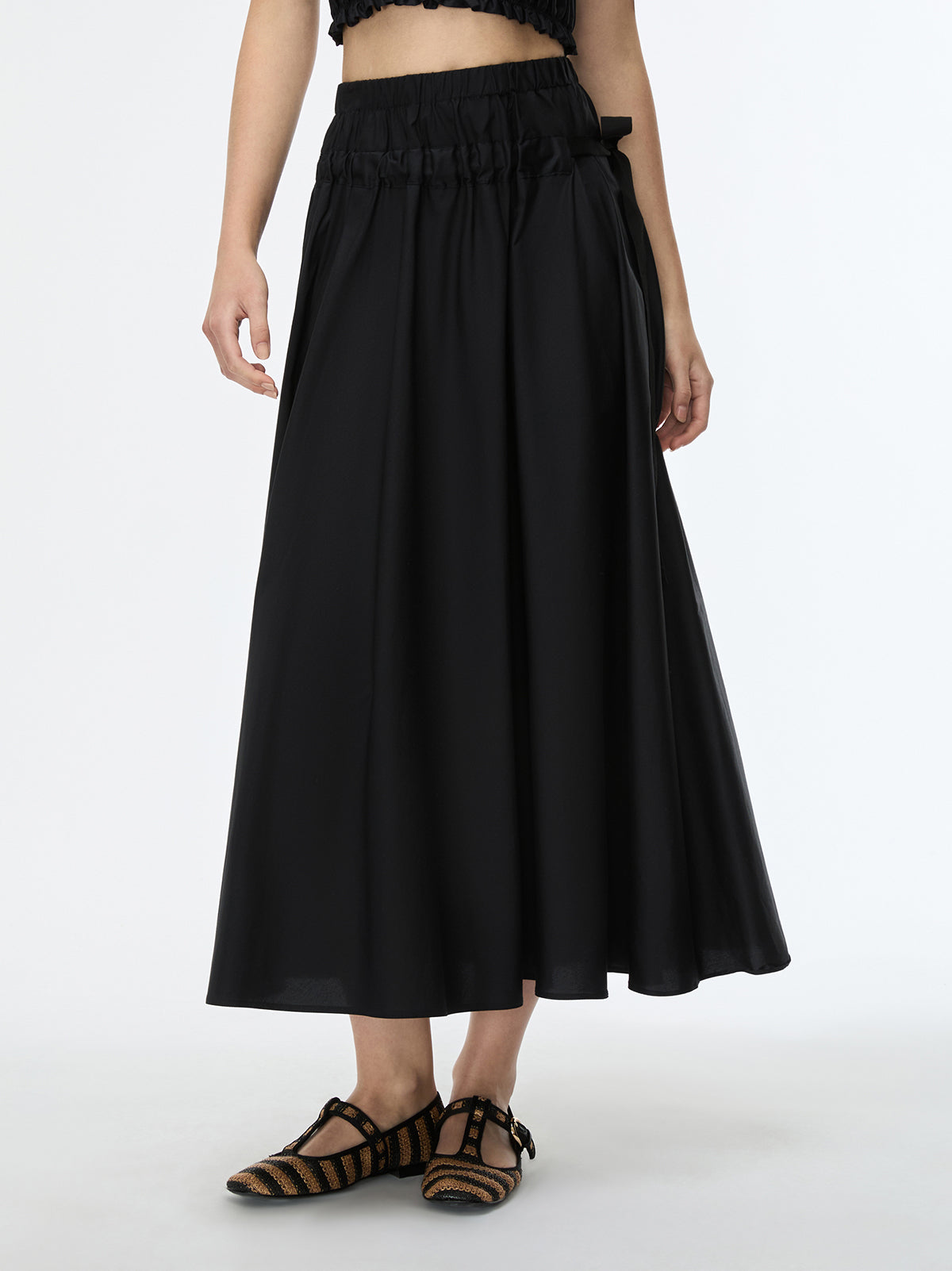 Person wearing a black skirt with a white background