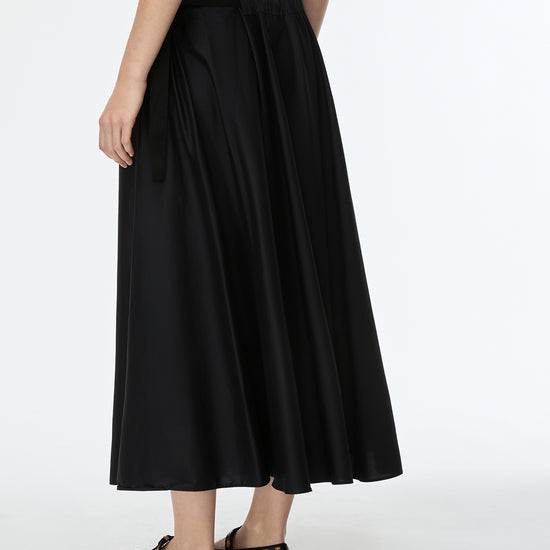 Black skirt worn by a person on a white background