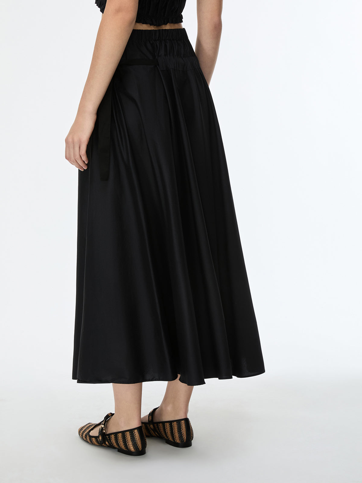 Black skirt worn by a person on a white background