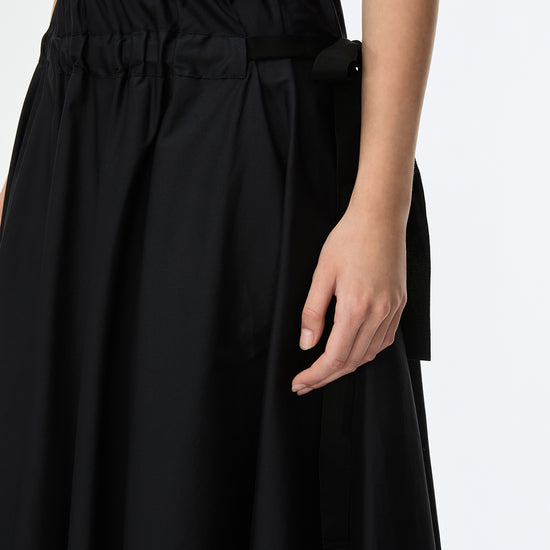 Black skirt worn by a person on a white background
