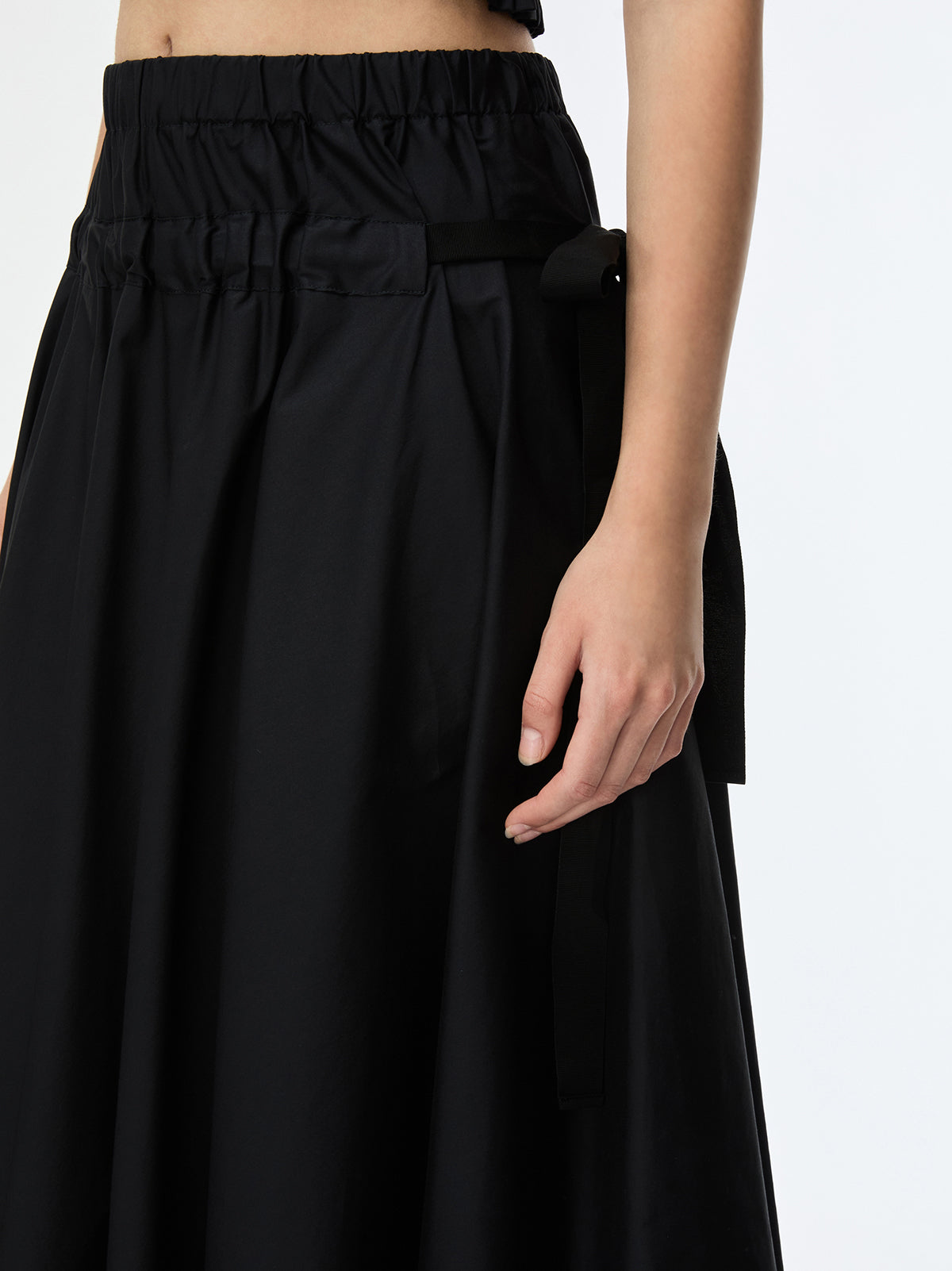 Black skirt worn by a person on a white background