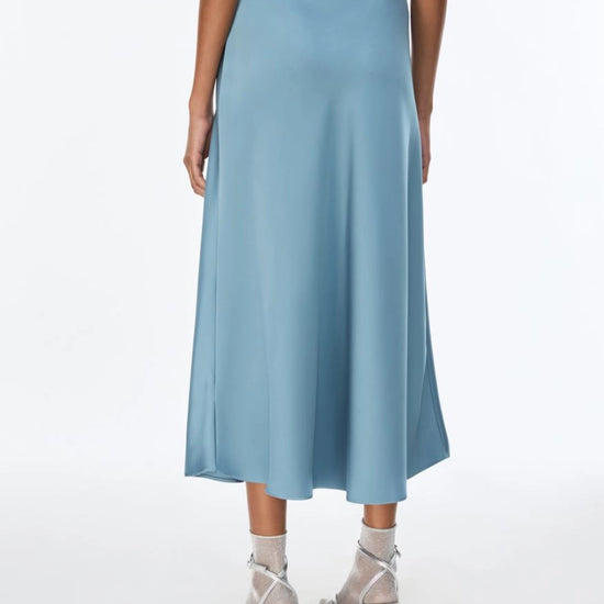 woman wearing light blue satin skirt rear view