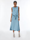 A woman modeling a sleeveless light blue midi dress with a knotted waist and tie detail, paired with clear high-heeled sandals, against a plain white studio background.