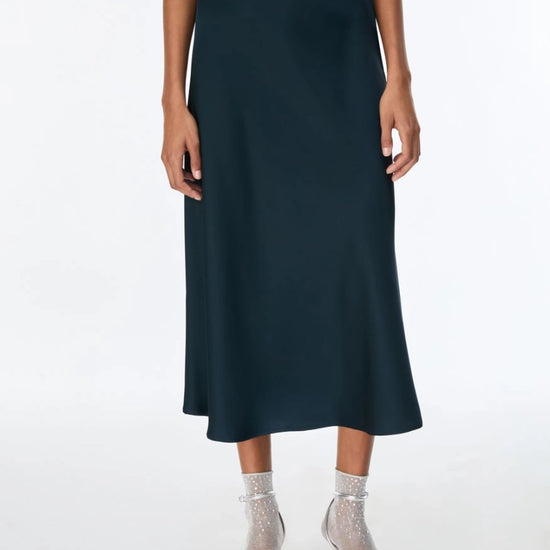 woman wearing teal blue skirt eith silver heels 