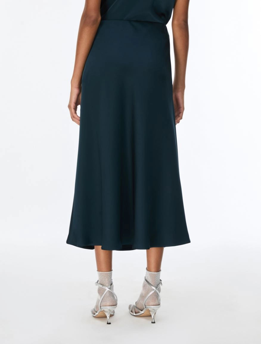 woman wearing teal blue skirt with silver heels rear view