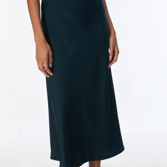 Dark green skirt and top worn by a person on a white background