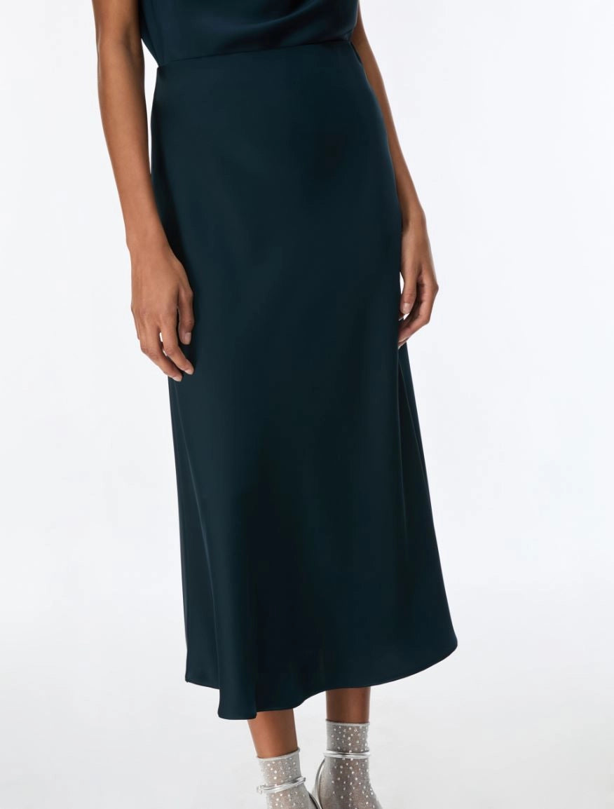 Dark green skirt and top worn by a person on a white background