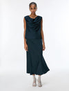 Woman wearing a dark green sleeveless top and skirt set on a white background