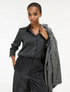 woman wearing grey satin shirt on a white background side view