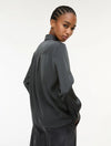 woman wearing grey satin shirt on a white background side view