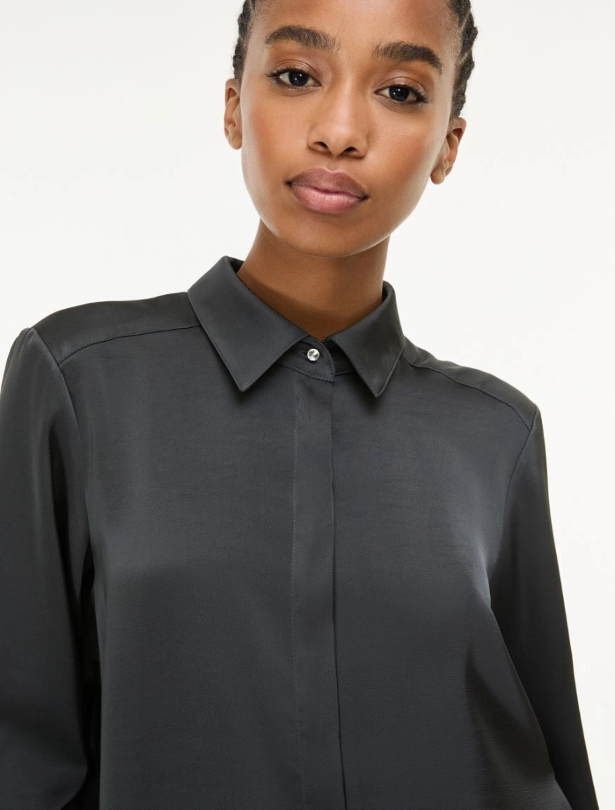 woman wearing grey satin shirt on a white background side view